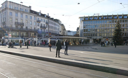 People walking on road along buildings