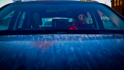 Portrait of young woman sitting in car