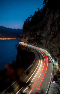 Light trails on road against sky at night