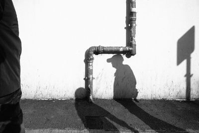 Man standing on road against wall