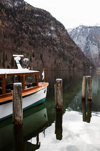 Wooden posts in lake against mountains