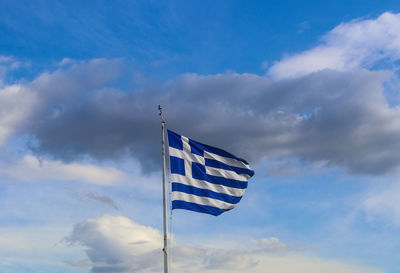 Low angle view of flag against blue sky