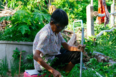 Side view of man gardening in yard