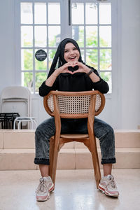 Portrait of young woman sitting on sofa at home
