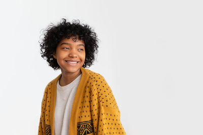 Portrait of young woman standing against white background