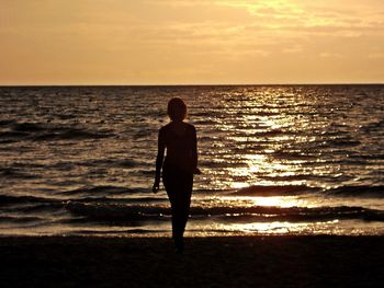 Full length of silhouette man standing on beach during sunset