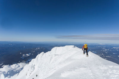 A man climbs to the summit of mt. hood in oregon.