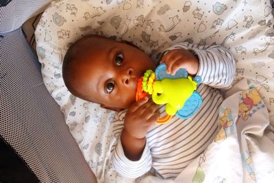 Portrait of cute baby lying on bed at home