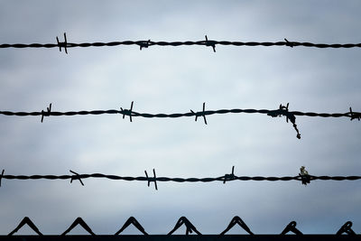 Close-up of barbed wire against sky