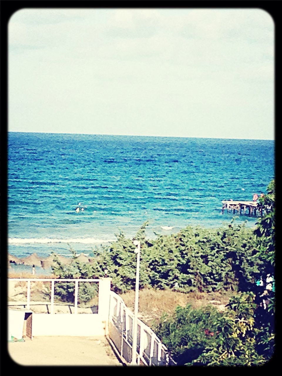 sea, horizon over water, water, transfer print, beach, tranquil scene, scenics, tranquility, beauty in nature, clear sky, auto post production filter, nature, railing, sky, blue, shore, day, plant, built structure, idyllic