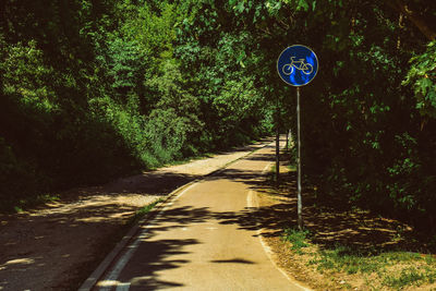 Road sign by trees in forest