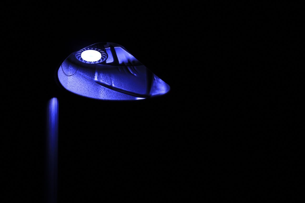 CLOSE-UP OF ILLUMINATED BLUE LIGHT AGAINST BLACK BACKGROUND