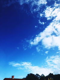 Low angle view of silhouette trees against blue sky