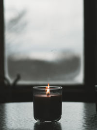 Close-up of lit candle against sky