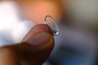 Close-up of hand holding contact lens