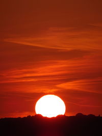 Low angle view of silhouette mountain against orange sky