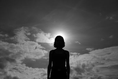 Rear view of silhouette woman standing against sky