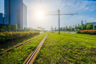 Railroad tracks in city against sky