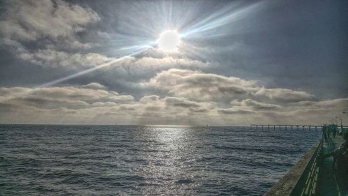 Scenic view of sea against cloudy sky on sunny day