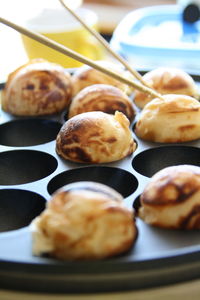 Close-up of fresh takoyakis in baking sheet on table