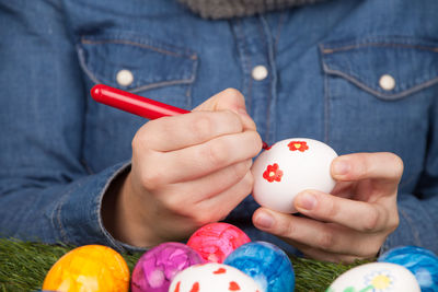 Midsection of woman drawing on eggs during easter