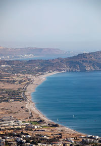 High angle view of townscape by sea against sky