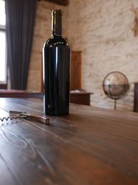 Wine bottle and corkscrew on table