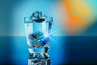 Digital composite image of glass against blue background