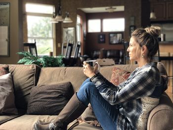 Woman sitting on sofa at home