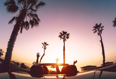 People at car against sky during sunset