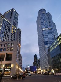 Low angle view of illuminated buildings against sky in city