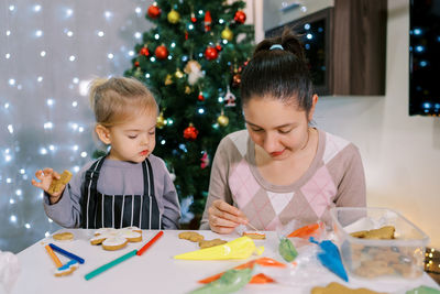 Side view of mother and daughter at home