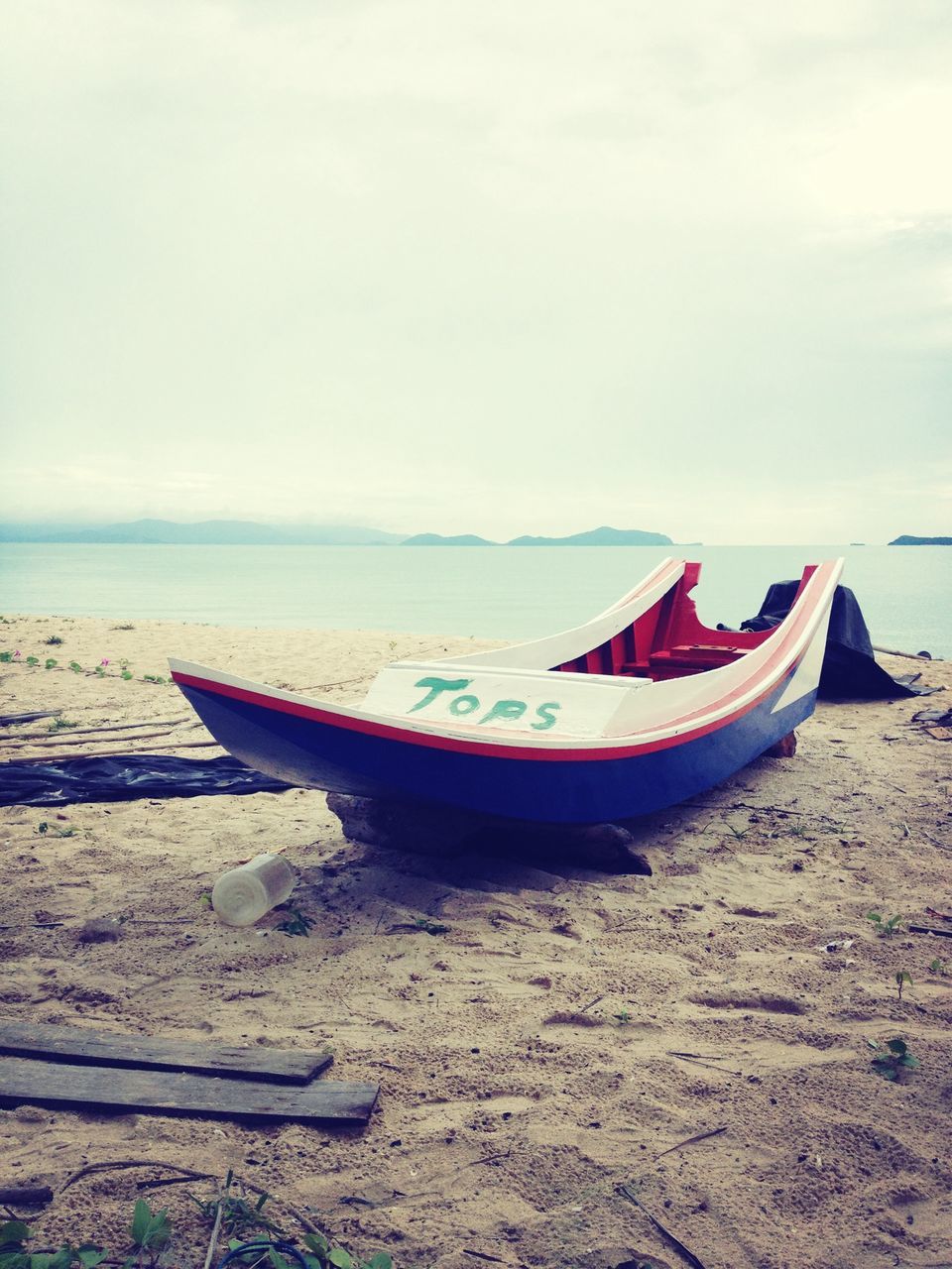 sea, nautical vessel, beach, boat, water, transportation, shore, moored, mode of transport, sand, horizon over water, sky, tranquility, tranquil scene, nature, beauty in nature, scenics, travel, outdoors, coastline