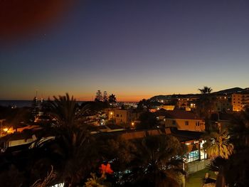 High angle view of illuminated buildings against sky at night