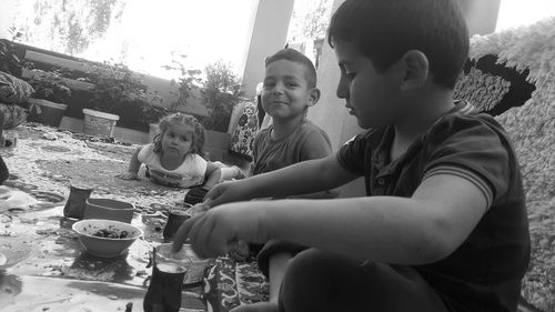 Siblings playing with painting equipment at yard