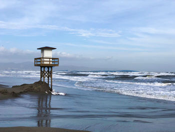 Scenic view of sea against sky with life guard tower