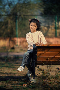 Portrait of young man sitting on field