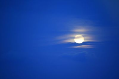 Low angle view of moon against blue sky