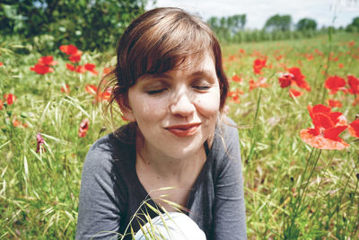 Close-up of smiling young woman sitting on field