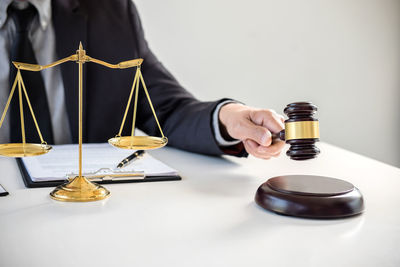 Cropped image of judge banging gavel on table