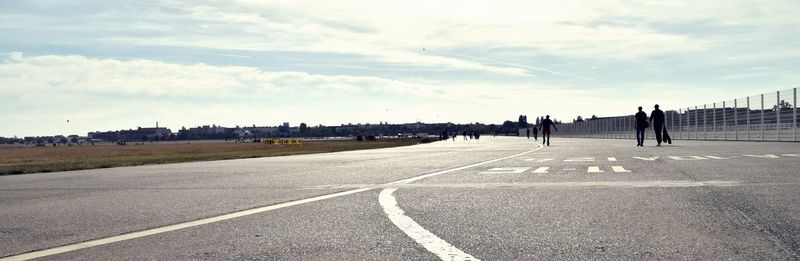 People on road in city against sky