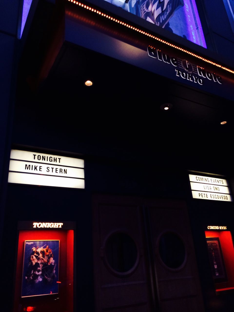 illuminated, architecture, built structure, low angle view, text, night, western script, communication, building exterior, lighting equipment, indoors, red, non-western script, no people, blue, capital letter, building, information, window, sign