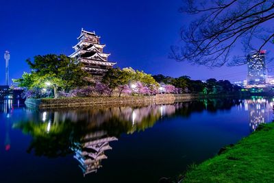 Scenic view of lake by building against sky at night