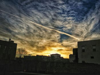 Buildings against cloudy sky at sunset