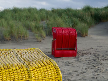 Red chairs on sand at beach