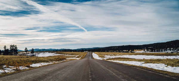 Road amidst trees against sky