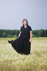 Woman in dress standing on field
