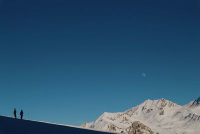 Low angle view of desert against clear blue sky