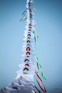 Low angle view of kite hanging against clear blue sky