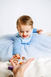 Cute baby girl in blue princess dress playing toys with mom at home. kids dresses for birthday